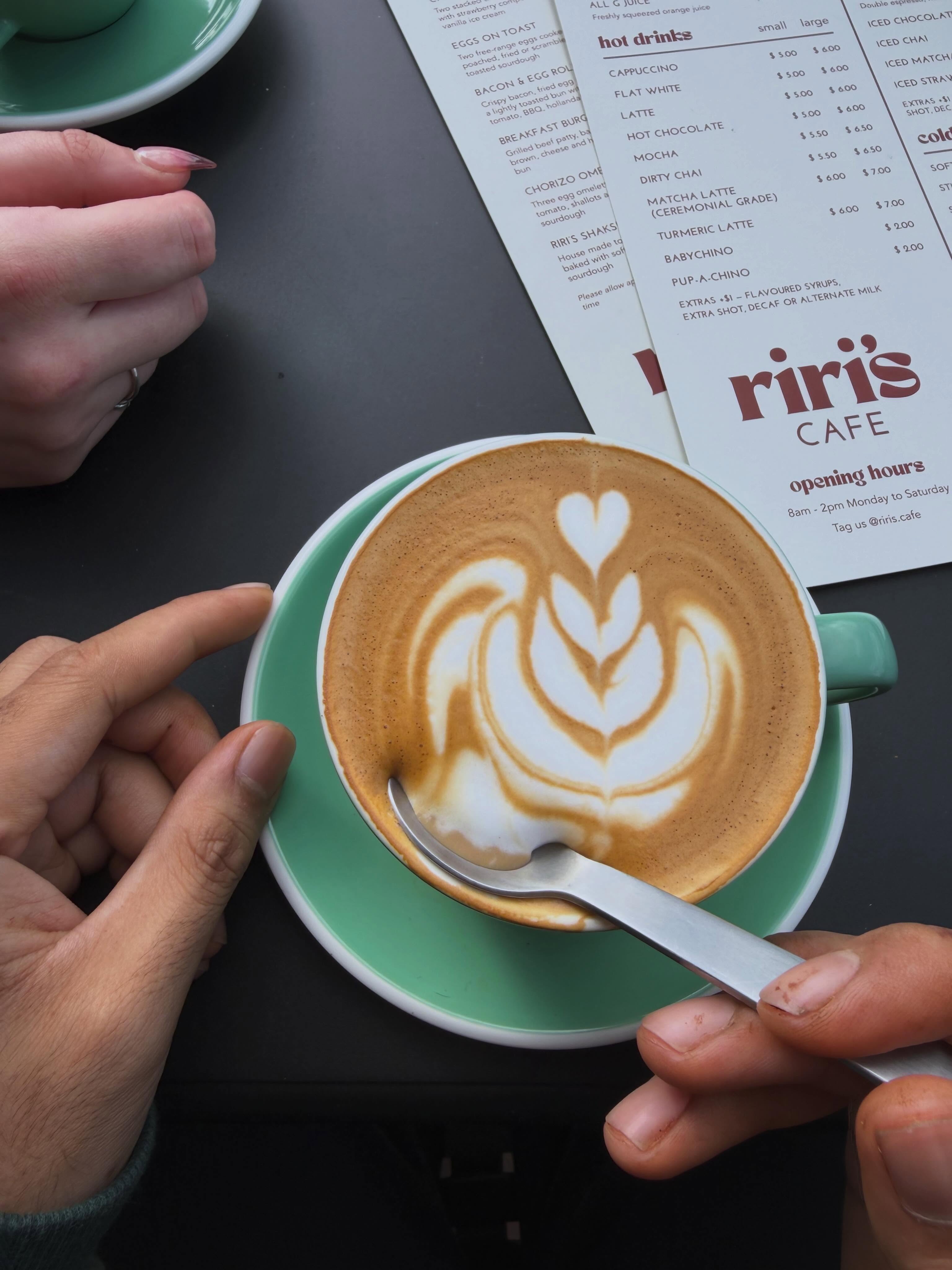 A White Horse Coffee latte with leaf art on the Riri's menu