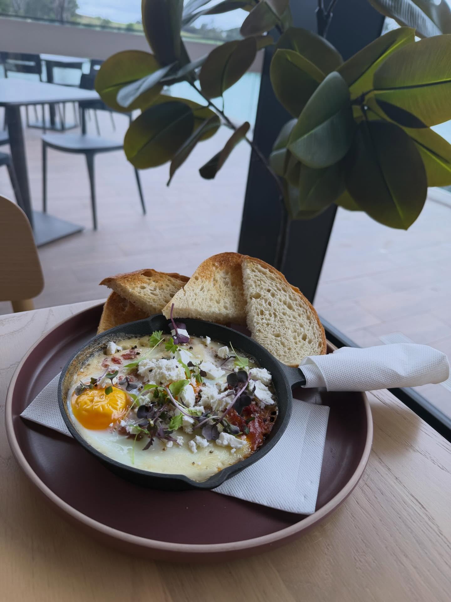 Riri's shakshuka eggs in a cast-iron pan with sourdough